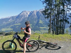 Monika auf dem E-Bike mit erhobenen Daumen kurz vor der Abfahrt.